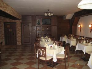 a restaurant with white tables and chairs and a screen at Hotel Villa Ofir in Sandanski