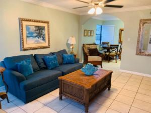 a living room with a blue couch and a table at Royal North Beach in Clearwater Beach