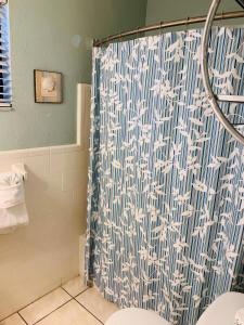 y baño con ducha y cortina azul y blanca. en Royal North Beach, en Clearwater Beach