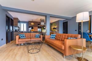 ein Wohnzimmer mit zwei orangenen Sofas und einer Küche in der Unterkunft Apartamento Superior Bali in Málaga