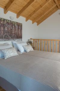 a large bed in a room with wooden ceilings at ONOMY Country House Vathypetro in Archanes