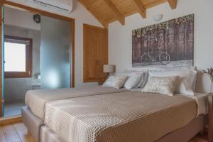 a bedroom with a large bed with a painting on the wall at ONOMY Country House Vathypetro in Archanes +25 photos