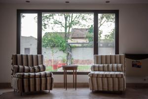 two chairs and a table in a room with a window at Hotel del Ingenio in Libertador General San Martín