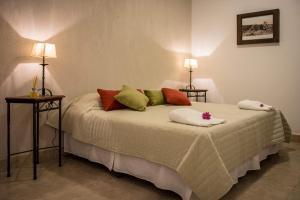 Un dormitorio con una cama con dos lámparas encima. en Hotel del Ingenio, en Libertador General San Martín
