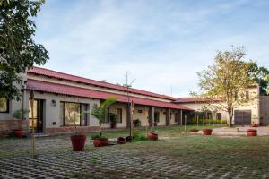 un edificio con techos rojos y plantas en un patio en Hotel del Ingenio, en Libertador General San Martín