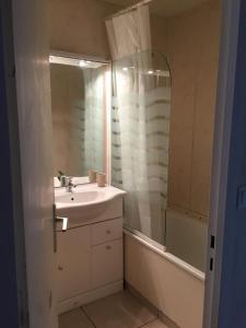 ein Badezimmer mit einem Waschbecken, einem Spiegel und einer Badewanne in der Unterkunft Grand 2 pièces traversant au Val Claret, 4 à 6 pers in Tignes
