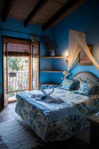 a bedroom with a bed with a blue wall at Lo Racó de Peret in Camarles