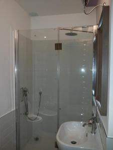 W łazience znajduje się szklana kabina prysznicowa i umywalka. w obiekcie Goldoni77 w Mediolanie