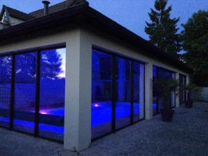 Saint-Léger-sur-DheuneにあるLes Lodgesの夜間の窓に青い照明が灯る建物