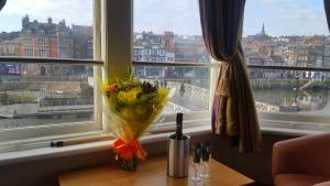 a vase of flowers on a table in front of a window at The Dolphin Hotel in Whitby
