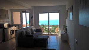 ein Wohnzimmer mit einem Sofa und eine Küche mit einem Balkon in der Unterkunft Apartmento Atlantico in Tazacorte
