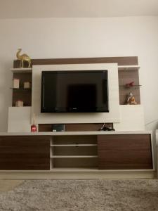 un centro de entretenimiento con TV de pantalla plana en CASANOGh NOVO TEMPO, en Curitiba