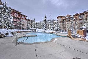 a swimming pool with snow covered trees and buildings at Slopeside Solitude Condo - Walk to Ski Lifts! in Solitude