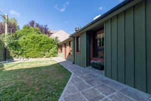 un edificio verde con una acera junto a un patio en Casas Lo de Tere en San Martín de los Andes