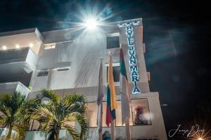 a hotel at night with flags in front of it at Hotel Juan Maria in Tuluá