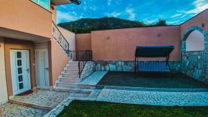 a chair sitting on the side of a house at Holiday Home Rozić - Villa with private seasonal heated pool in Mostar