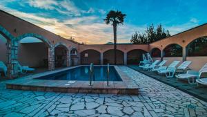 einem Pool mit Stühlen und einer Palme in einem Gebäude in der Unterkunft Apartments Rozić in Mostar