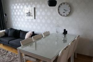 uma mesa de jantar com cadeiras e um relógio na parede em Tasokas 3h+k+s Nivalan ydinkeskustassa em Nivala