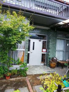 ein Haus mit einer weißen Tür und einem Balkon in der Unterkunft Ikkenya Kitagata in Okayama