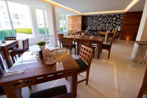 un restaurante con mesas y sillas de madera y ventanas en Hotel Posada Señorial en Cholula