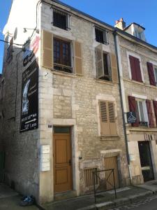 an old stone building with a brown door and windows at Chablis hyper Centre in Chablis