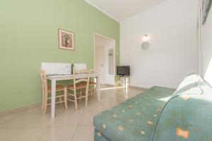 - une chambre avec une table, un lit, une table et des chaises dans l'établissement Apartments Maria Kukljica, à Kukljica