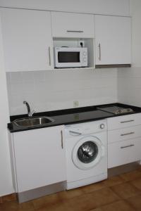 een keuken met een wastafel en een wasmachine bij Studio 88 - free Parking in Lloret de Mar