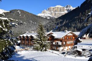 Una cabaña en las montañas con nieve en el suelo. en Appartamenti Agriturismo Cèsa Ciasates, en Canazei
