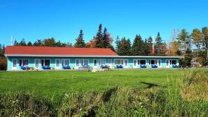 un bâtiment avec un champ devant lui dans l'établissement Atlantic View Motel, à Lunenburg