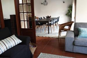 uma sala de estar com uma mesa de jantar e cadeiras em Carminho beach house em Vila do Conde