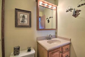a bathroom with a sink and a mirror and a toilet at Cozy Angel Fire Condo Less Than Half Mi to Resort! in Angel Fire