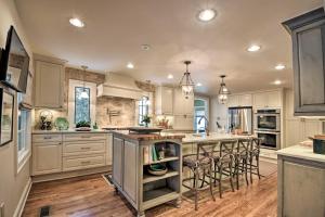a kitchen with white cabinets and a island with bar stools at Lush Mirror Lake Cottage Rental with Private Deck in Highlands