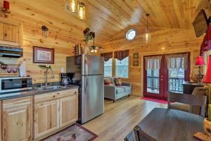 eine Küche mit einem Kühlschrank und ein Wohnzimmer in der Unterkunft Cozy Heber Springs Cabin with Deck and Dock! in Heber Springs