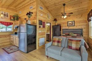 ein Schlafzimmer mit einem Bett, einem Kühlschrank und einem Sofa in der Unterkunft Cozy Heber Springs Cabin with Deck and Dock! in Heber Springs