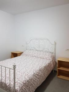 1 dormitorio con cama blanca y colcha blanca en Apartamento privado en una zona tranquila y próxima al aeropuerto TF norte y a la ciudad de San Cristóbal de la Laguna ., en La Laguna