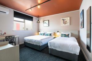 um quarto de hotel com duas camas e uma secretária em Nightcap at Fairfield em Fairfield