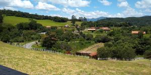 a person walking down a road on a hill at Chalés Roma in Santo Antônio do Pinhal