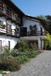 een wit gebouw met bloemen ervoor bij Agriturismo Fano's Farm in Suno