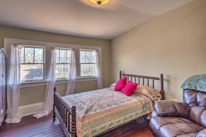 a bedroom with a bed and a couch and two windows at Historic Home 8 Mi to Bristol Motor Speedway in Bristol