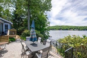 um pátio com uma mesa e um guarda-chuva em The Point on Highland Lake Near Mtn Creek Resort em Highland Lakes