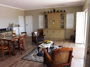 uma sala de estar com mesa e cadeiras e uma cozinha em Karoo-Palet em Oudtshoorn