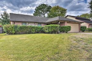 a house with a grass yard in front of it at Pet-Friendly Missouri City Home with Fenced-In Yard! in Missouri City