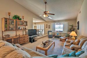 a living room with couches and a flat screen tv at Mesa Home with Pool about 7 Mi to Riparian Preserve! in Mesa
