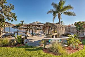 a dock with a table and chairs on the water at Waterfront Merritt Island Vacation Rental with Pool! in Merritt Island
