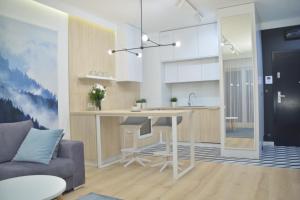 a kitchen and living room with a table and a couch at Last Floor Apartment - Krakow City Center close to Old Town in Kraków