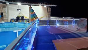 a swimming pool at night with blue lights at Mirante Beach House in Piaçabuçu