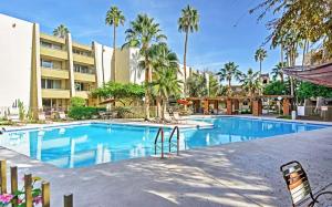 een groot zwembad met palmbomen en een gebouw bij Family Condo with Pool Less Than 1 Mi to Old Town Scottsdale in Scottsdale