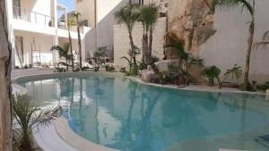 a large swimming pool in the middle of a building at Le Cale Camera Privata in Residence in Favignana