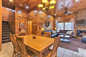 een eetkamer en een woonkamer met een houten tafel bij Sevierville Cabin with Hot Tub and Large Deck! in McCookville