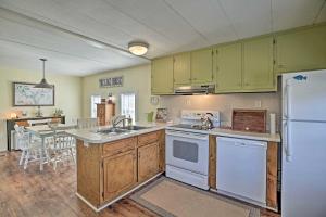 una cucina con armadi verdi e frigorifero bianco di Lake Sinclair Crooked Creek Cottage with Fire Pit! a Eatonton